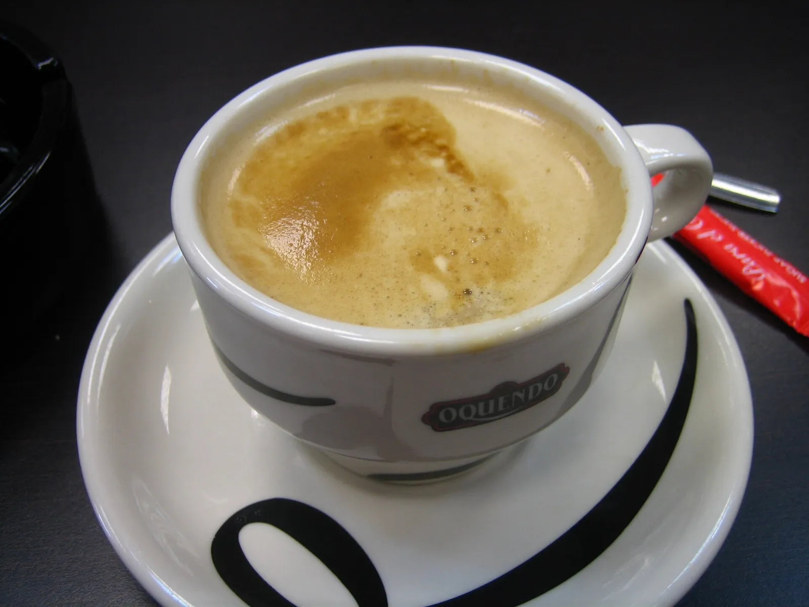 A cup of cafe con leche on a saucer. The photo was not taken in Tampa.
