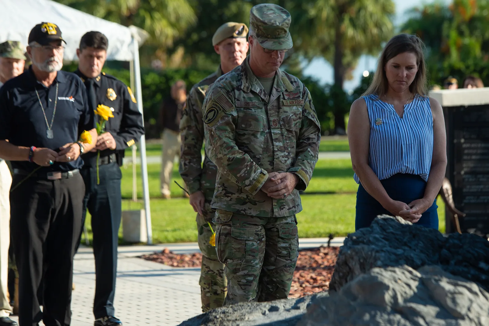 Service members and guests hold flowers at a remembrance ceremony at U.S. Special Operations Command on MacDill Air Force Base in Tampa.