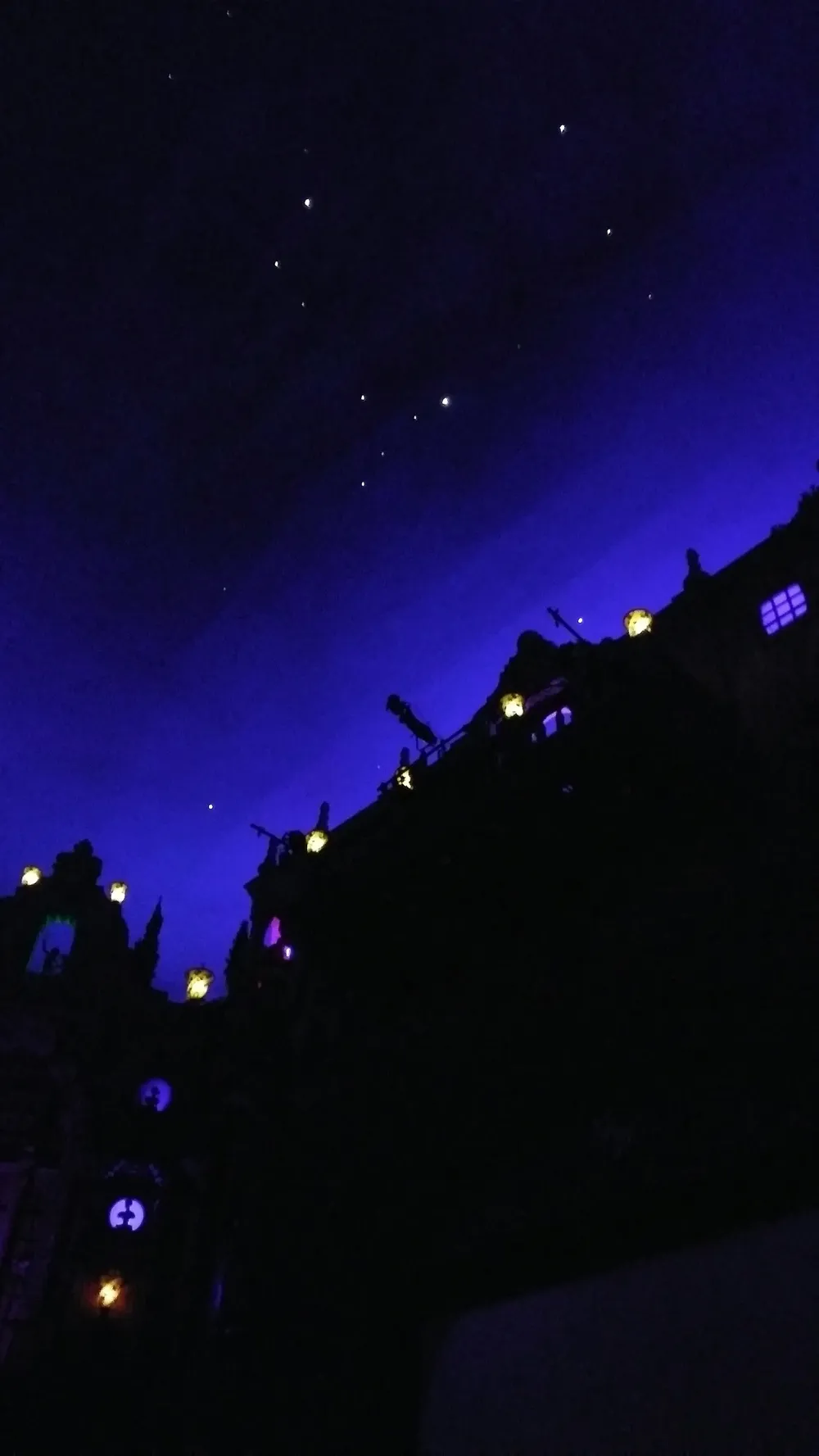 The ceiling of the Tampa Theatre auditorium, painted dark blue to look like a night sky, with small lights for stars above ornate plaster walls.