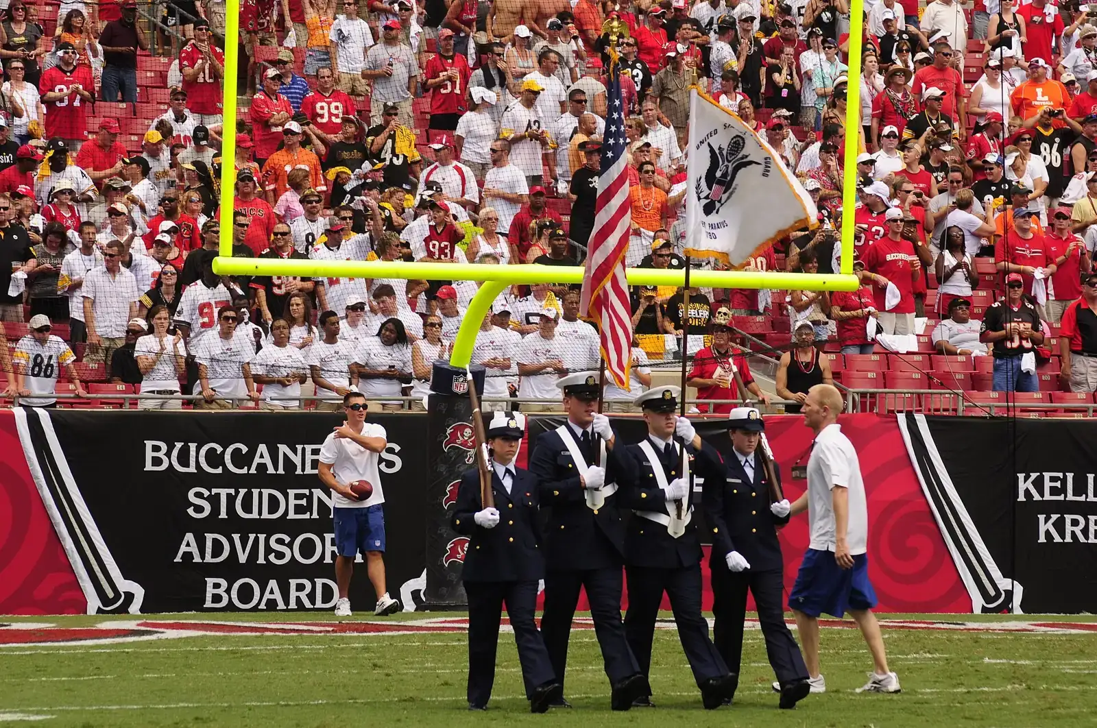 A Coast Guard color guard from Air Station Clearwater carries the flags onto the field at Raymond James Stadium in Tampa.